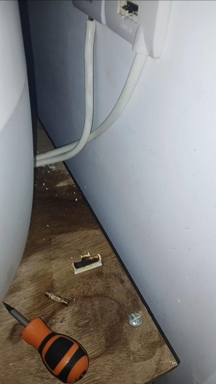 Blackened fuse holder removed from a damaged immersion-heater fused spur during a repair
